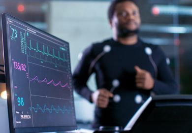 Close-up Shot of a Monitor With EKG Data. Male Athlete Runs on a Treadmill with Electrodes Attached to His Body while Sport Scientist Holds Tablet and Supervises EKG Status in the Background