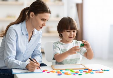 A woman with a clipboard observes a child