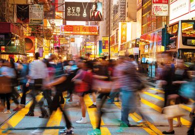 Motion Blurred Pedestrians walking over a busy crosswalk in Hong Kong