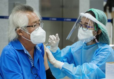  doctor or nurse giving covid antivirus vaccine shot to senior man patient wearing protective face mask