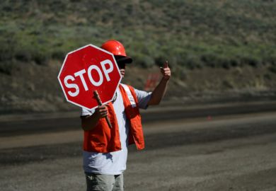 A man holds a 'stop' sign