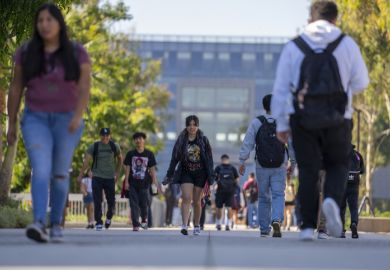 University students walk past the Natural Sciences and Mathematics build on the campus of Cal State University.