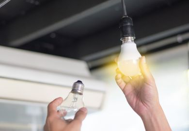 man changing compact-fluorescent (CFL) bulbs with new LED light bulb