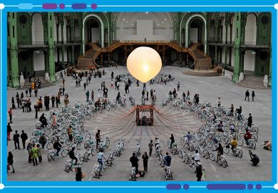 People pedal on bicycles equipped with dynamos which light up gigantic luminous bulbs as part of an art installation in Paris. To illustrate the mergers of universities in France.