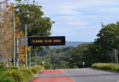 Road safety sign saying please slow down