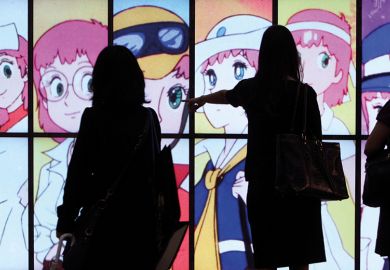 People silhouetted against a screen showing Japanese anime 