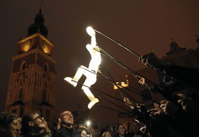 Puppet artists of the performance group Dundu move a puppet on the Main Square in Cracow, Poland to illustrate Scientists fear creeping political influence over Polish academy