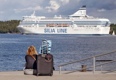 A woman is sitting on the quayside waiting for the boat with her luggage in  Lidingo, Sweden to illustrate Grant deadlines ‘create disparity’