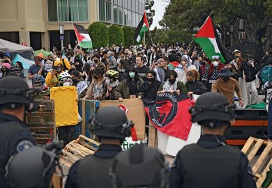 Pro-Palestinian demonstrators confront police as they clear an encampment after students occupied the Physical Sciences Lecture Hall at the University of California to illustrate Colleges ‘declare war’ on Gaza protest movement ahead of new year