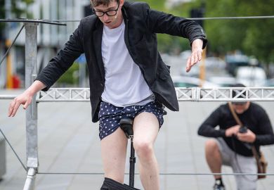 Street performer removes his trousers while riding a unicycle Christchurch, New Zealand to illustrate New Zealand universities ‘losing money’ on crucial subjects