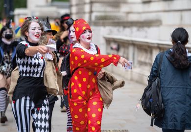 Protestors dressed as clowns hand out fake money in Westminster, London to illustrate Record £1.3 million severance pay for English sector leaders