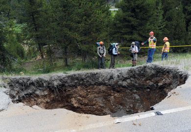 Hikers looking at a sinkhole that measures 25x20 feet and approximately 50-60 feet deep in Colorado to illustrate Review finds billion-dollar hole in Johns Hopkins medicine budget