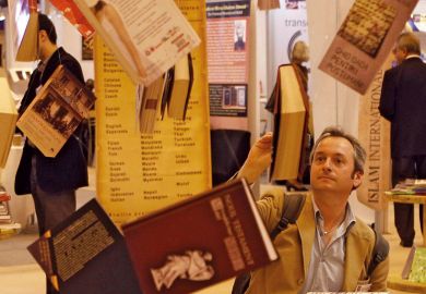 A man reads a book hanging at Earls Court Exhibition Centre in London to illustrate Don’t wait to tackle open access books cash challenge, REF told