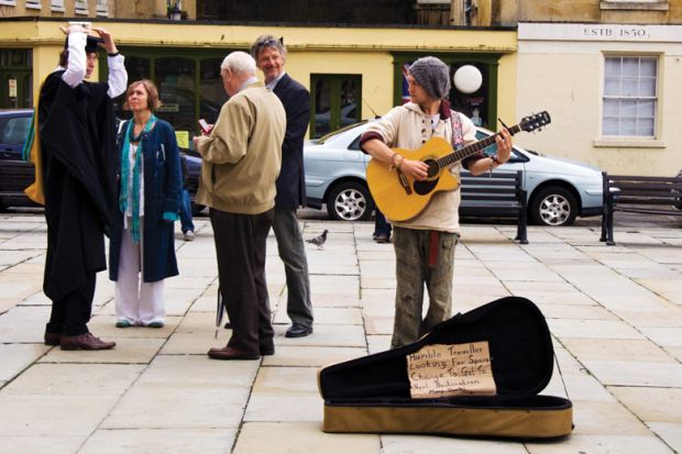 Busker watching a graduating student and his family