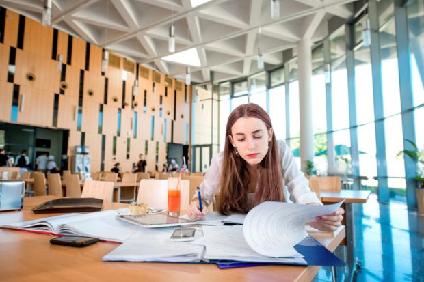 A woman studying in a university or college canteen