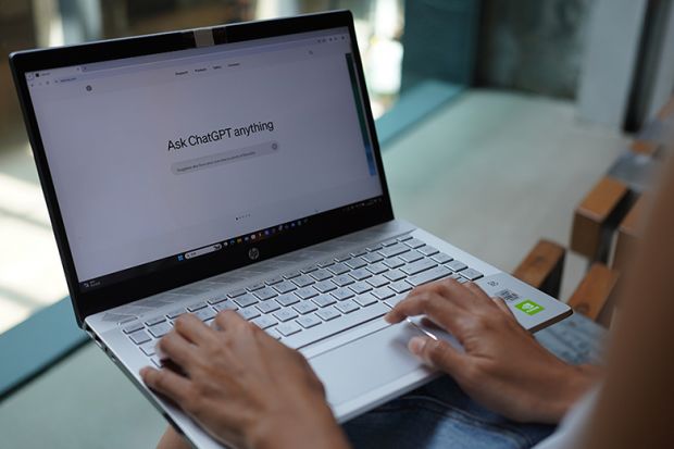 A woman browses OpenAi website on her laptop. On the screen it says "Ask ChatGPT anything". Illustrating increased use of AI by students in part of their assessments