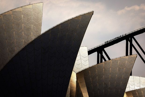 People climb the Sydney Harbour Bridge behind the Sydney Opera House, illustrating the soaring costs of educating Australian university students