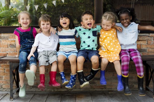 Children in wellington boots, arm in arm, representing collegiality in higher education