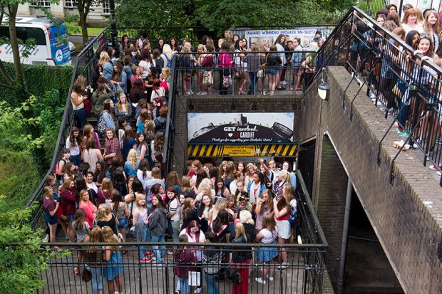 Crowd of fans queueing for a gig on stairs at Cardiff University, illustrating the university's plans to increase the staff-student ratio.