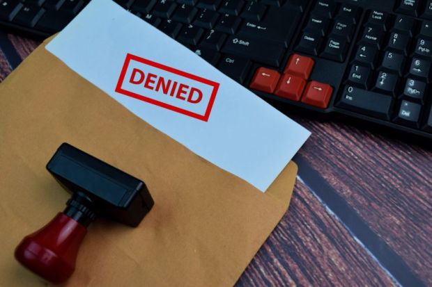 Envelope, with paper sticking out of it, word 'denied' stamped on it