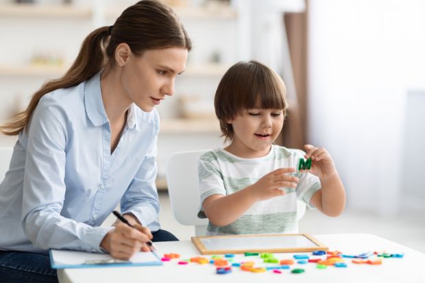 A woman with a clipboard observes a child