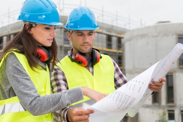 Engineers on building site checking plans