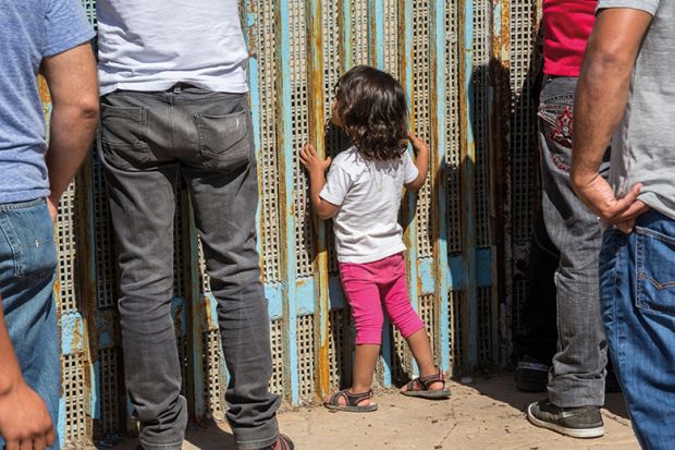 people stand at a fence