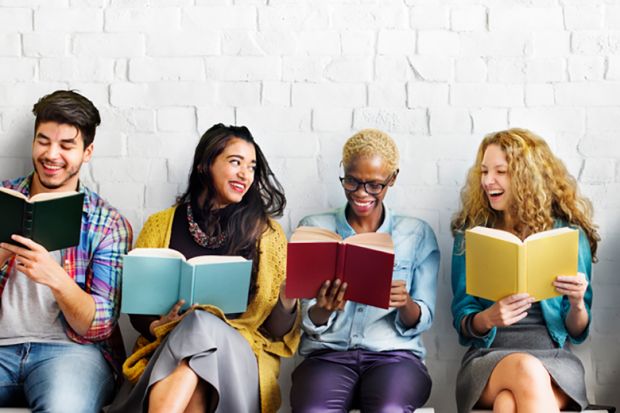 Four people sitting in a row reading books