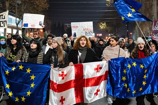 Georgia pro-Europe demonstrators hold Georgian and European flags during a protest against the Government's postponement of European Union accession talks until 2028, outside the Parliament in central Tbilisi, Georgia, on December 11, 2024