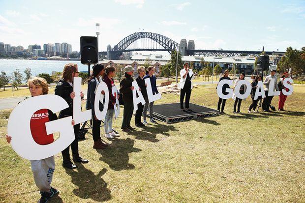 people holding letters spelling GOALS 