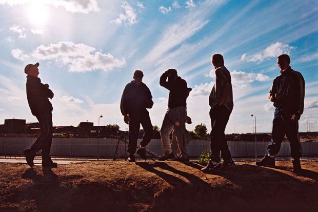 Group of teenage boys hang out on wasteland