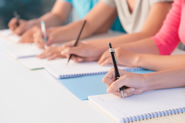 Students writing by hand