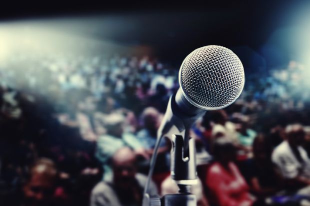 View from behind a microphone of a crowded meeting room