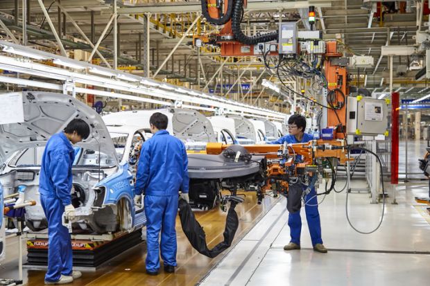 Workers install cars on the Shanghai Volkswagen factory assembly line.