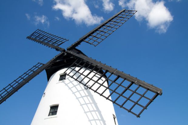 Old windmill against blue sky