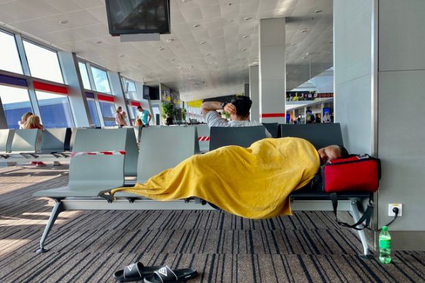 Kiev Ukraine-July 2021: A tired man sleeps on a bench at the airport while waiting for his transit flight.