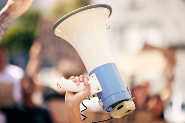 A megaphone is held in the air at a demonstration