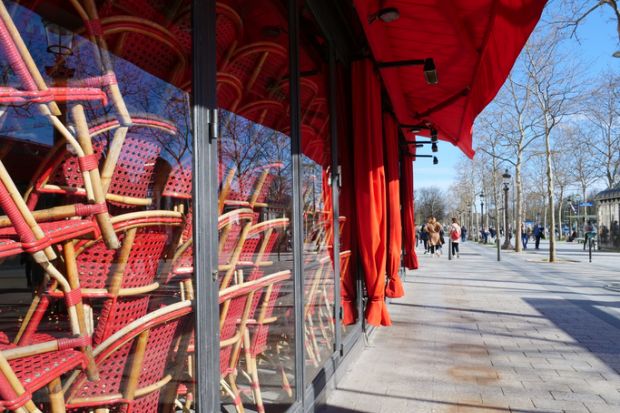 Stacked chairs inside a closed restaurant in Paris