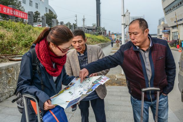  Female tourist seeing the map for summer travel in Zhangjiajie, China.