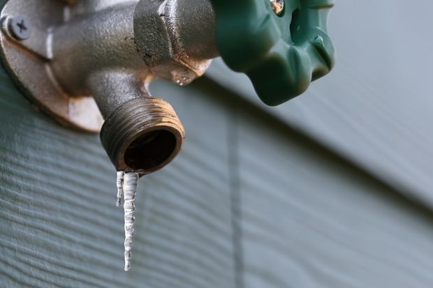 Photo of a frozen exterior faucet (hose bib) with icicles hanging from the end.