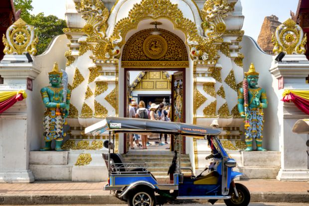 Tuk tuk in front of the entrance of Wat Chedi Luang, Chiang Mai, Thailand,