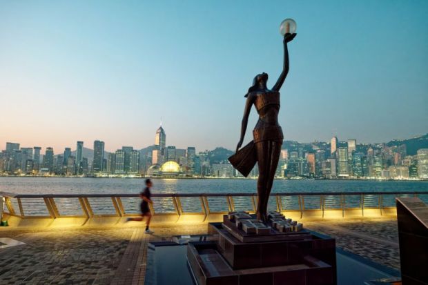 Hong Kong cityscape view from across Victoria Harbor in the morning, view of the Avenue of Stars with modern buildings background.