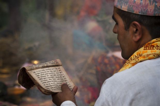 Nepalese Brahman reading Hindu religious mantras.