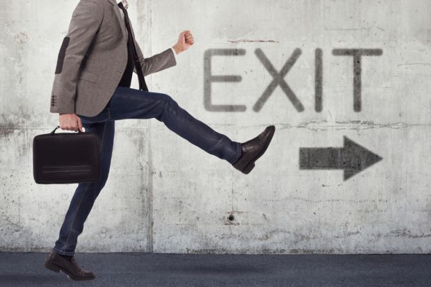 Male academic walking in direction of exit sign