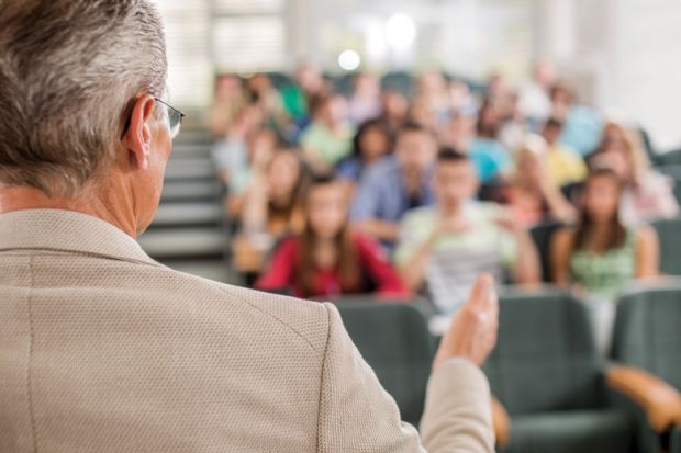 Male teacher giving lecture to hall of university students