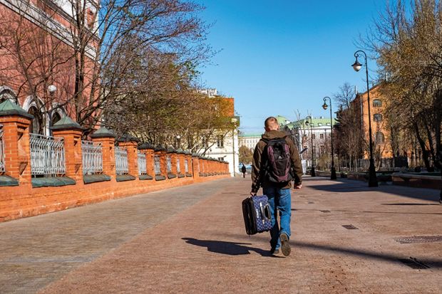 Moscow, Russia. A man carries a suitcase in the street. To illustrate an exiled Russian scholar.