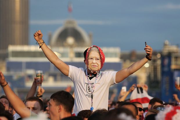 Man in crowd in England football shirt with Queen mask