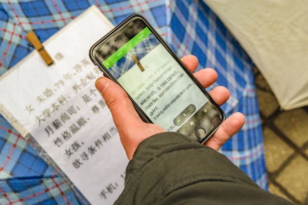 Man using google translate to read chinese letters at people square, shanghai, china