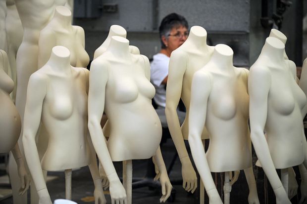 A woman works at a mannequin manufacturer with female mannequins missing heads and lower body , illustrating the female data gap as researchers record gender identity rather than sex.