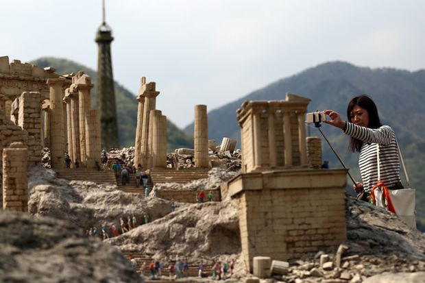 A visitor photographs a scale model of the Parthenon at Tobu World Square theme park in Nikko, Japan. Illustrating a plan to shrink the higher education sector fairly.